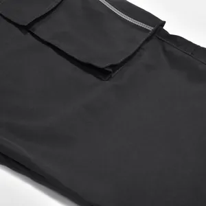 Primer plano de pantalones cargo negros con bolsillo con cremallera y solapa de cierre