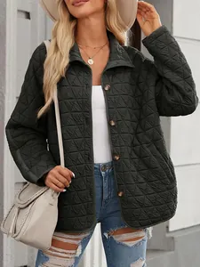 Detail of dark green quilted jacket with minimalist buttons and textured pattern