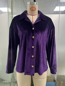 Detail view of a purple velvet long-sleeve shirt with a classic collar and buttons on a mannequin.