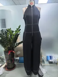 Detailed view of a black sleeveless jumpsuit with stand collar and white contrast stitching.