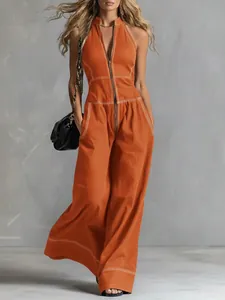 Detail view of women's orange sleeveless wide-leg jumpsuit with white contrast stitching