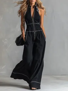 Detail of black sleeveless wide-leg jumpsuit with white contrast stitching on a model.