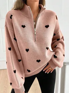Detalle de jersey de punto rosa con estampado de corazones negros y media cremallera