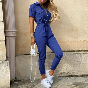 Outdoor full-body shot of a casual blue short-sleeve jumpsuit with a waist belt