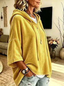 Vista detallada de una sudadera con capucha de terciopelo amarillo mostaza.