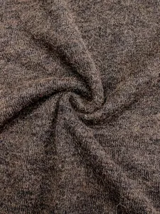 Detailed close-up view of dark brown knitted sweater fabric with soft marled texture
