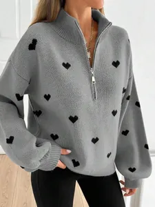 Detalle de jersey de punto gris con corazones negros y media cremallera