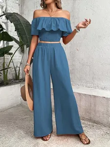 Blue two-piece set with off-shoulder ruffled smocked top and high-waisted wide-leg pants.