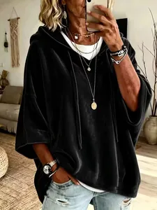 Primer plano de una sudadera con capucha de terciopelo negro extragrande en una modelo.