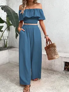Close-up of off-shoulder smocked ruffle top and matching wide-leg trousers set in blue