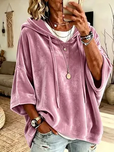 Detalle de una sudadera con capucha de terciopelo rosa para mujer con mangas 3/4 y estilo.