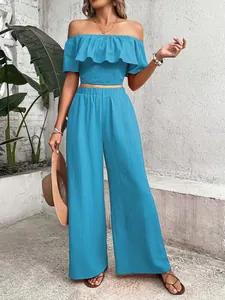 Full body detail view of blue off-shoulder smocked ruffle top and wide-leg pants set