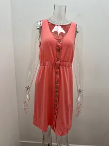 Close-up detail of a sleeveless peach dress with wooden buttons and elasticated waist.
