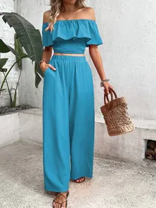 Close-up of blue smocked off-the-shoulder ruffle top and matching wide-leg trousers
