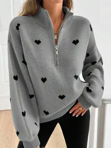 Detalle de un suéter de punto gris con corazones negros y media cremallera plateada