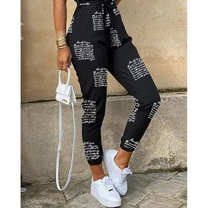 Detailed view of women's black jumpsuit featuring elegant white script print and waist belt