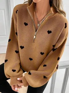Primer plano de jersey de punto color camel con corazones negros y cremallera de un cuarto
