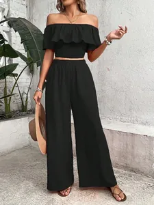 Elegant black two-piece set featuring off-the-shoulder smocked ruffle top and wide-leg pants