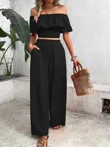 Casual black two-piece set featuring off-shoulder smocked crop top and wide-leg pants.