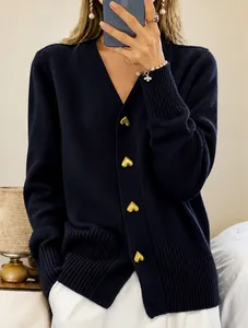 Detail of navy knit cardigan with decorative gold heart-shaped buttons and V-neck.