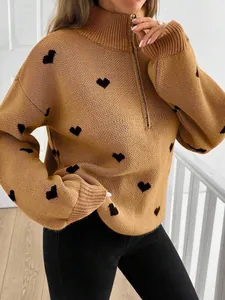 Detalle de jersey de punto color camel para mujer con estampado de corazones negros y cremallera