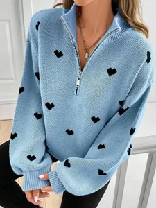 Detalle de suéter de punto azul con corazones negros y cremallera frontal
