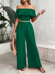 Stylish emerald green two-piece set featuring off-the-shoulder ruffle top and wide-leg trousers