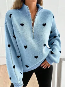 Detalle del jersey de punto azul claro para mujer con estampado de corazones y cremallera.