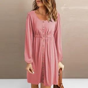Pink long-sleeved button-front dress with elastic waist and round neckline detail.