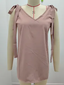 Détail du col en V et des nœuds d'épaule d'un caraco d'été de couleur mauve