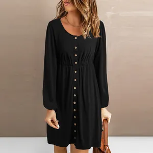 Detail of a chic black long-sleeved button-down dress featuring an elastic waist and round neck