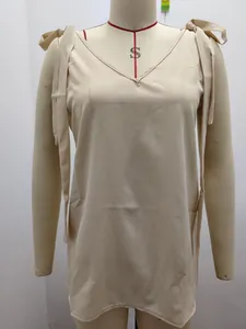 Vue de face d'un débardeur beige à col en V avec d'élégants nœuds réglables aux épaules.