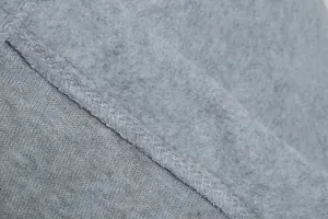 Close-up macro-opname van de zachte lichtgrijze fleecestof en duurzame overlock-stiksels