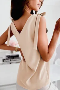 Vue détaillée des élégantes bretelles à nœud et du dos en V sur ce débardeur beige chic.