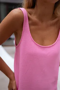 Close-up view of a pink waffle-knit sleeveless tank dress highlighting its soft fabric texture