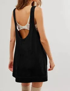 Close-up back view of a black corduroy sleeveless pinafore dress for a leisure vacation look.
