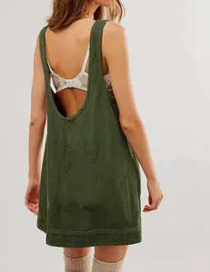 Detail view of green corduroy sleeveless pinafore dress featuring a deep open back