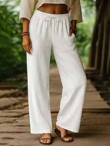 Close-up detail of white cotton linen wide-leg trousers with elastic drawstring waist