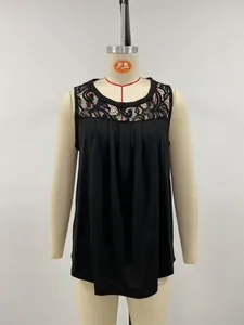 Detailed view of black sleeveless top featuring intricate lace trim and pleated chest