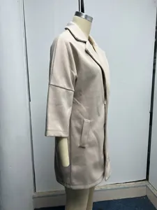 Détail latéral d'un manteau en laine beige pour femme avec revers et manches 3/4