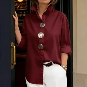 Detalle de camisa burdeos con cuello mao y botones metálicos plateados de gran tamaño