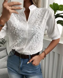 Detailed view of white V-neck stand-up collar blouse with intricate floral embroidery lace