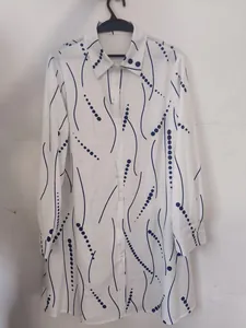 White long-sleeve shirt dress featuring blue wavy lines and dot pattern detail