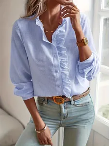 Detalle de elegante camisa a rayas azules con volantes y botones dorados de oficina