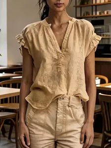 Detail of bohemian v-neck cotton linen top with ruffled sleeves in a cafe setting
