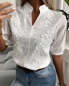 Detailed view of white V-neck lace embroidered shirt with puff sleeves