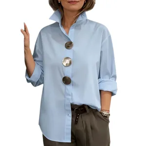 Detalle de camisa azul claro con cuello mao y botones metálicos de gran tamaño.
