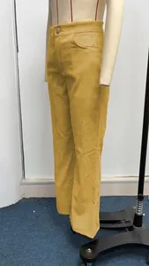 Detail view of high-waisted mustard yellow corduroy micro-flare trousers on a mannequin