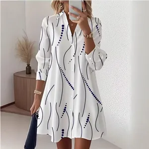 Detail shot of white shirt dress featuring abstract blue wave and polka dot patterns.