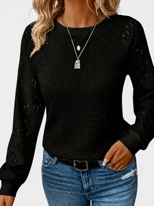 Detail van de textuur van de zwarte casual top met lange mouwen en opengewerkte kant voor dames